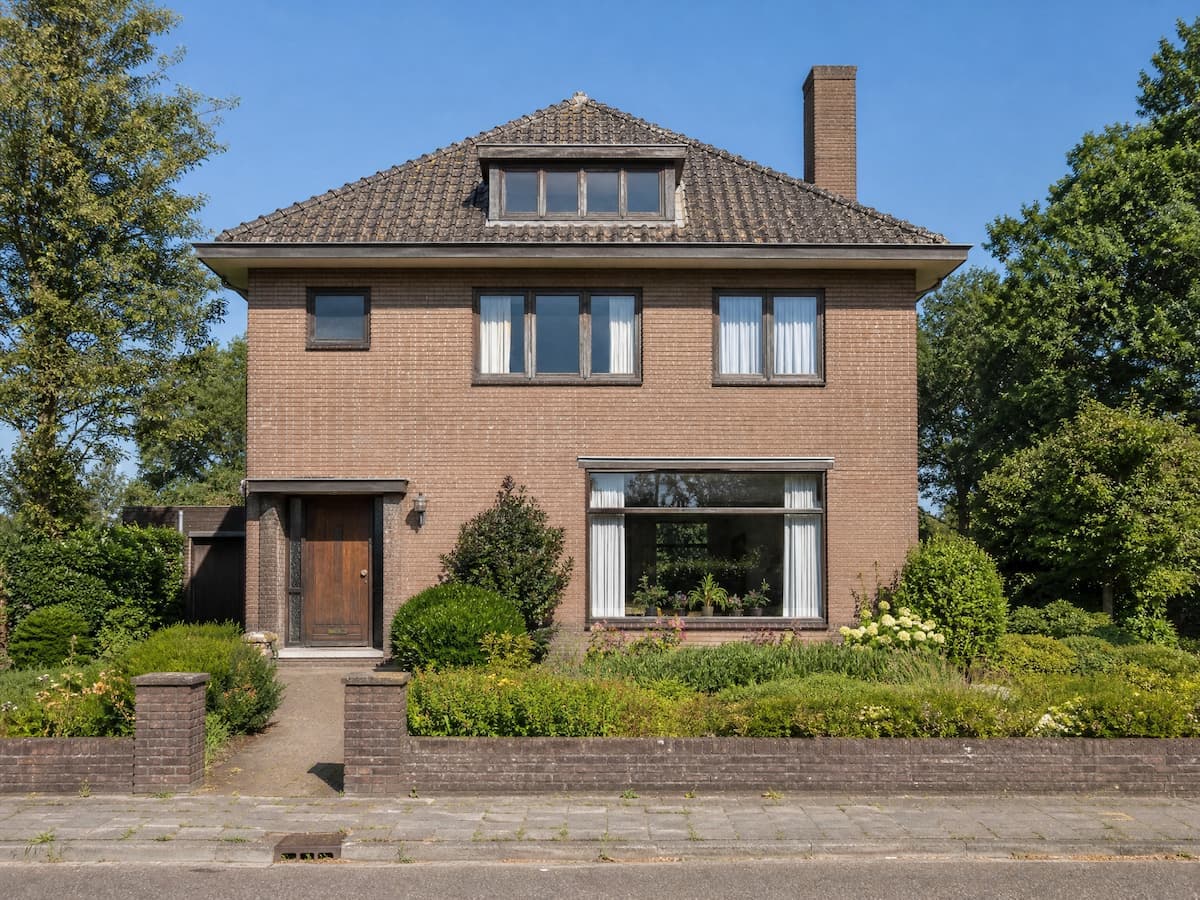 Vrijstaande woning met oude, donkere houten kozijnen vóór vervanging