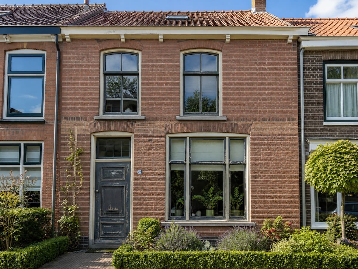 Tussenwoning met versleten kozijnen en oude voordeur vóór de renovatie